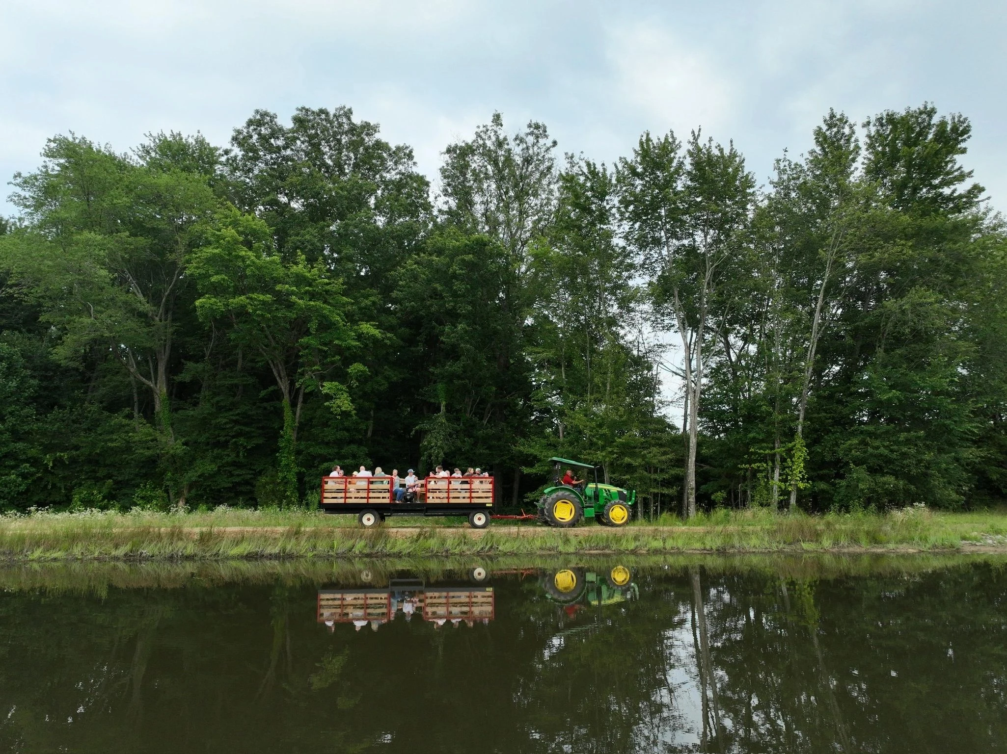 A tractor and passenger wagon beside the pond at Big Sky Farm.