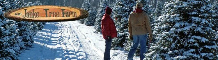 Visitors beside snowy tree rows and a Janke Tree Farm sign.