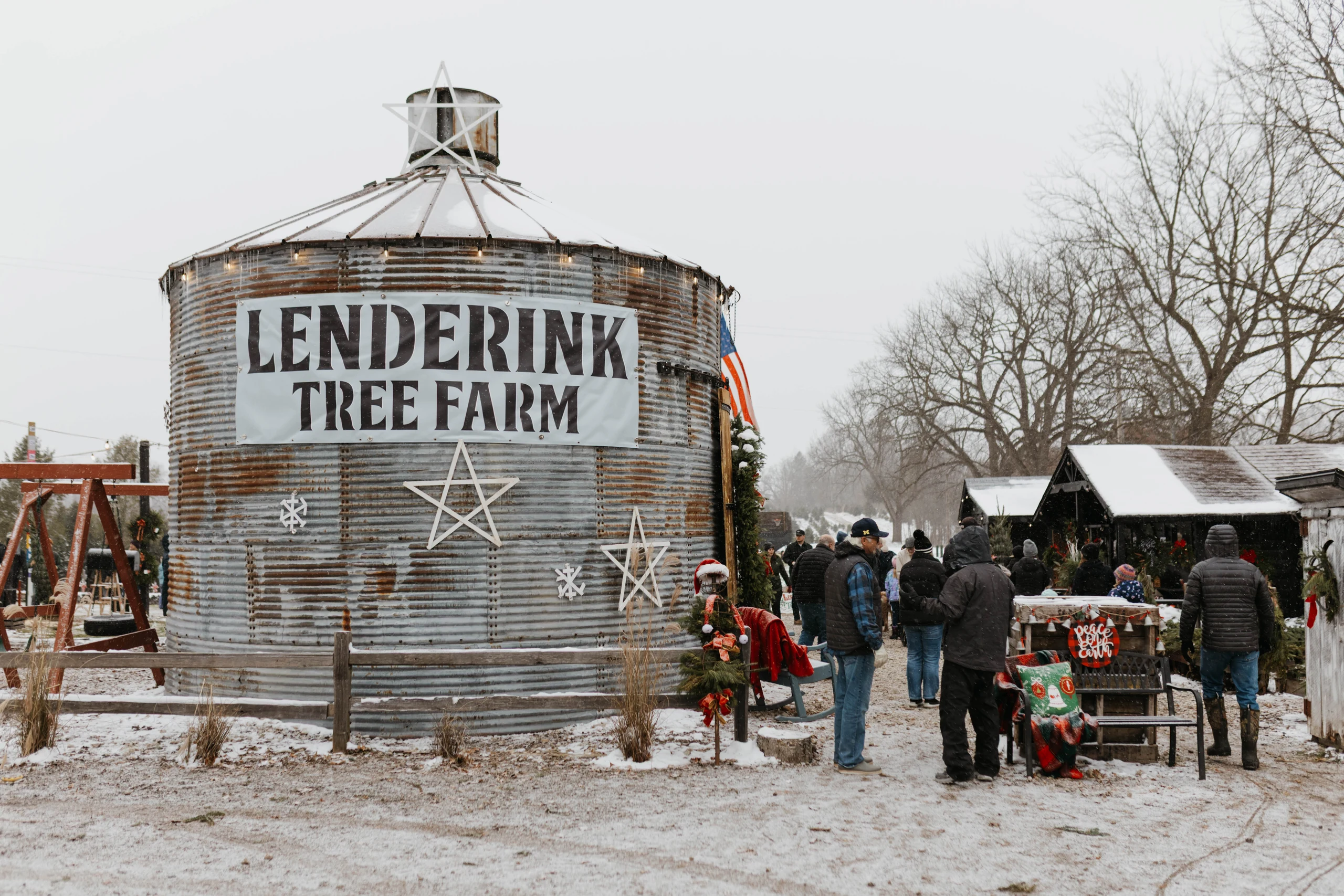 Visitors in the snow outside a grain bin marked Lenderink Tree Farm.