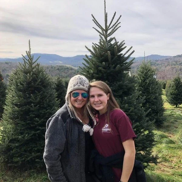 Two visitors beside trees at Mistletoe Meadows
