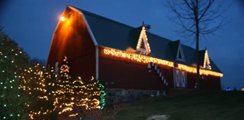 Oney’s barn illuminated with Christmas lights at dusk