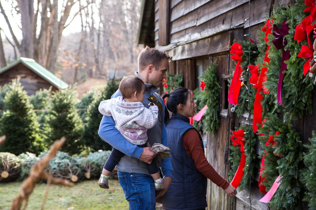A family browsing handmade wreaths outside Saltsman’s barn.