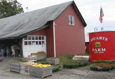 Stuart’s red farm barn with the farm sign beside it.