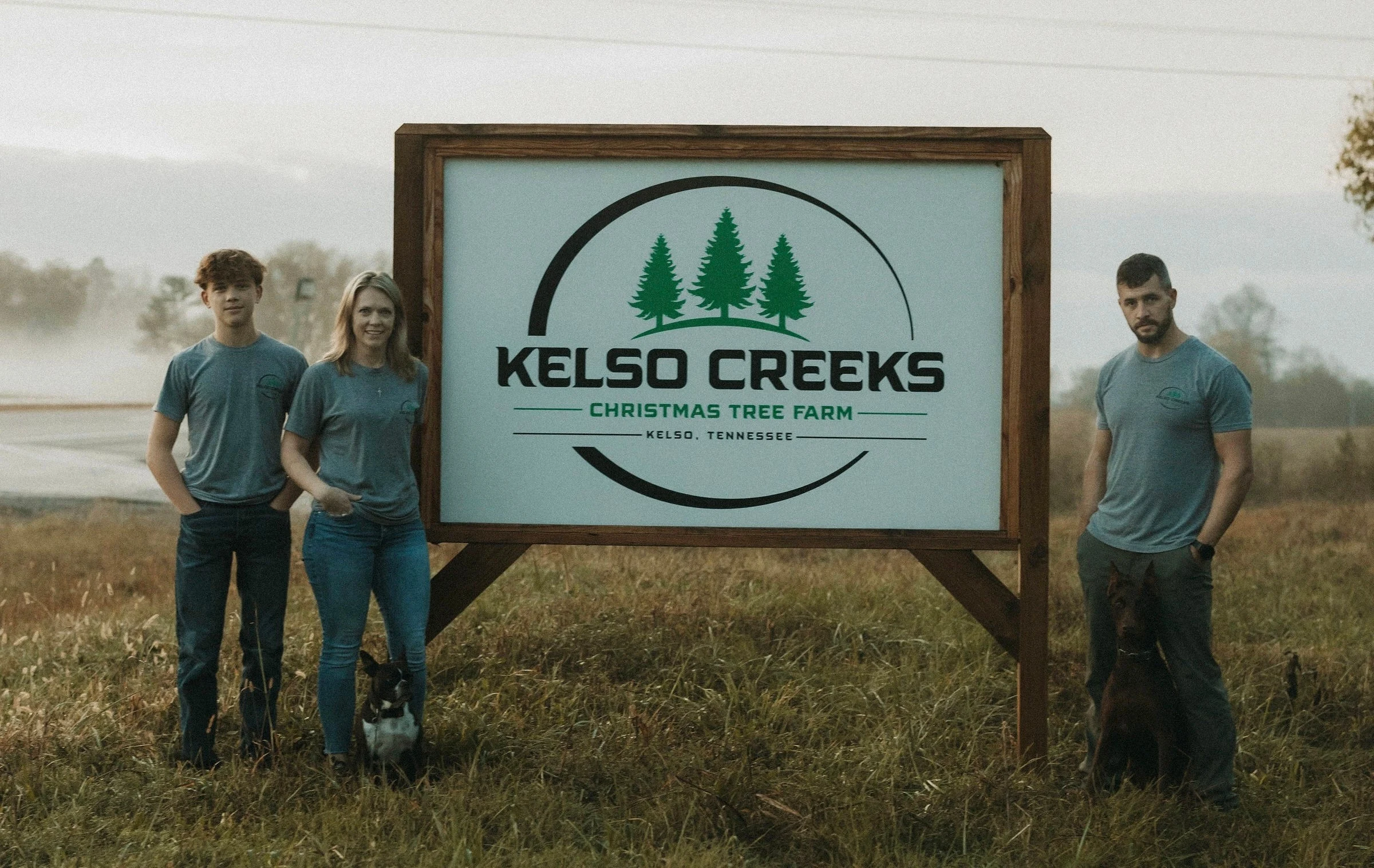 Visitors beside the Kelso Creeks farm sign.